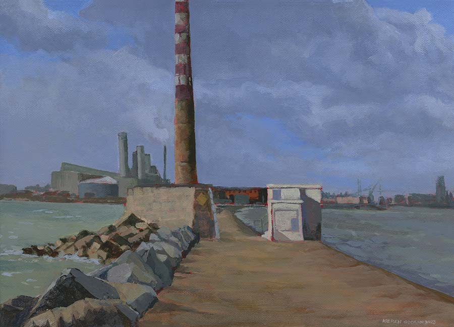 view of the Poolbeg Chimneys belonging to the old power station in Dublin on a grey day. View is from the south great wall looking back towards the city.